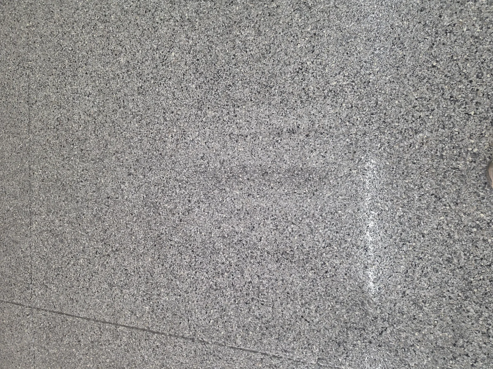 Close-up of gray and black full-flake garage floor coating texture by Armorforge Coatings