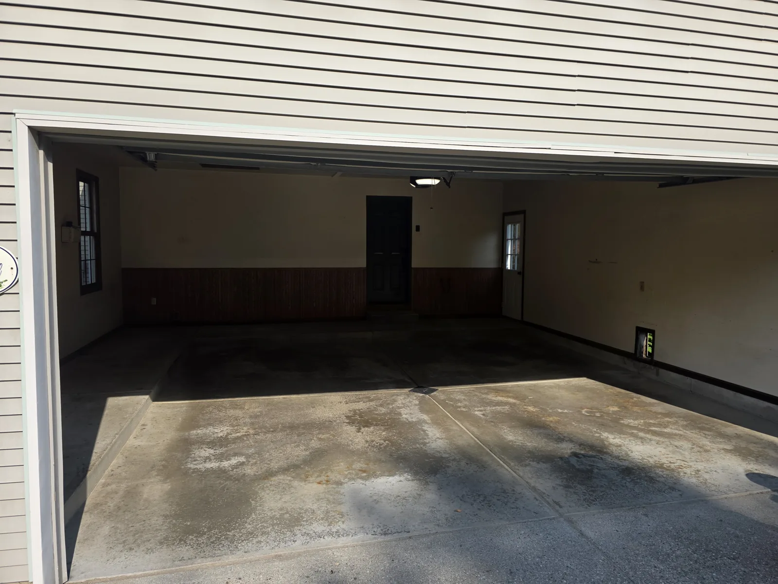 Before: worn, stained two-car garage concrete floor in Grand Rapids, MI, prior to Armorforge Coatings polyaspartic coating