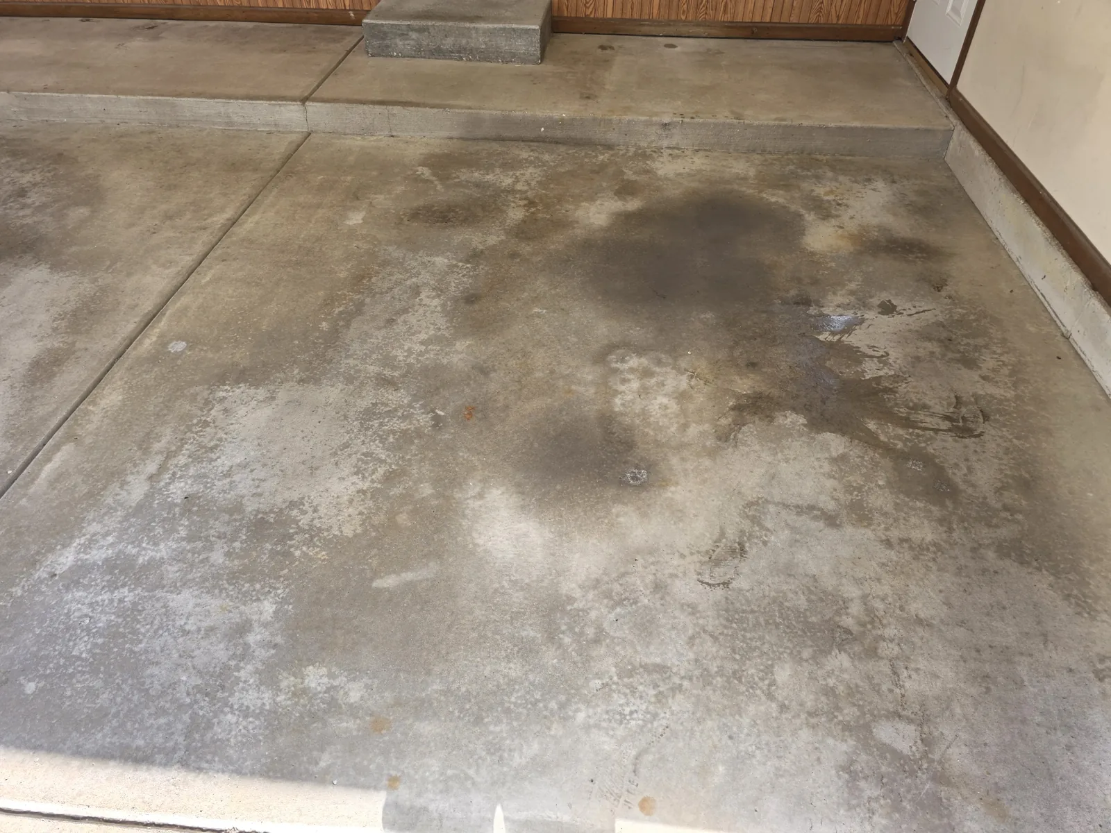 Before: oil- and moisture-stained bare garage concrete in Grand Rapids, MI