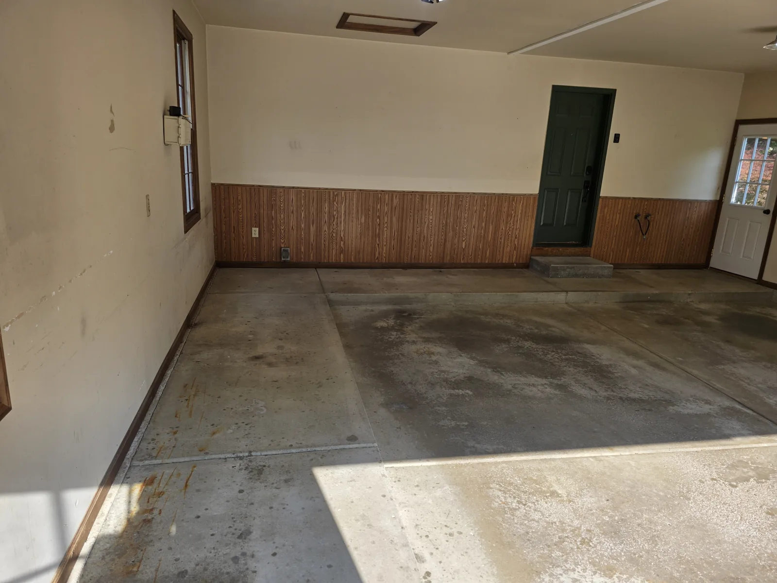 Before: oil- and moisture-stained bare concrete garage floor in West Michigan before coating